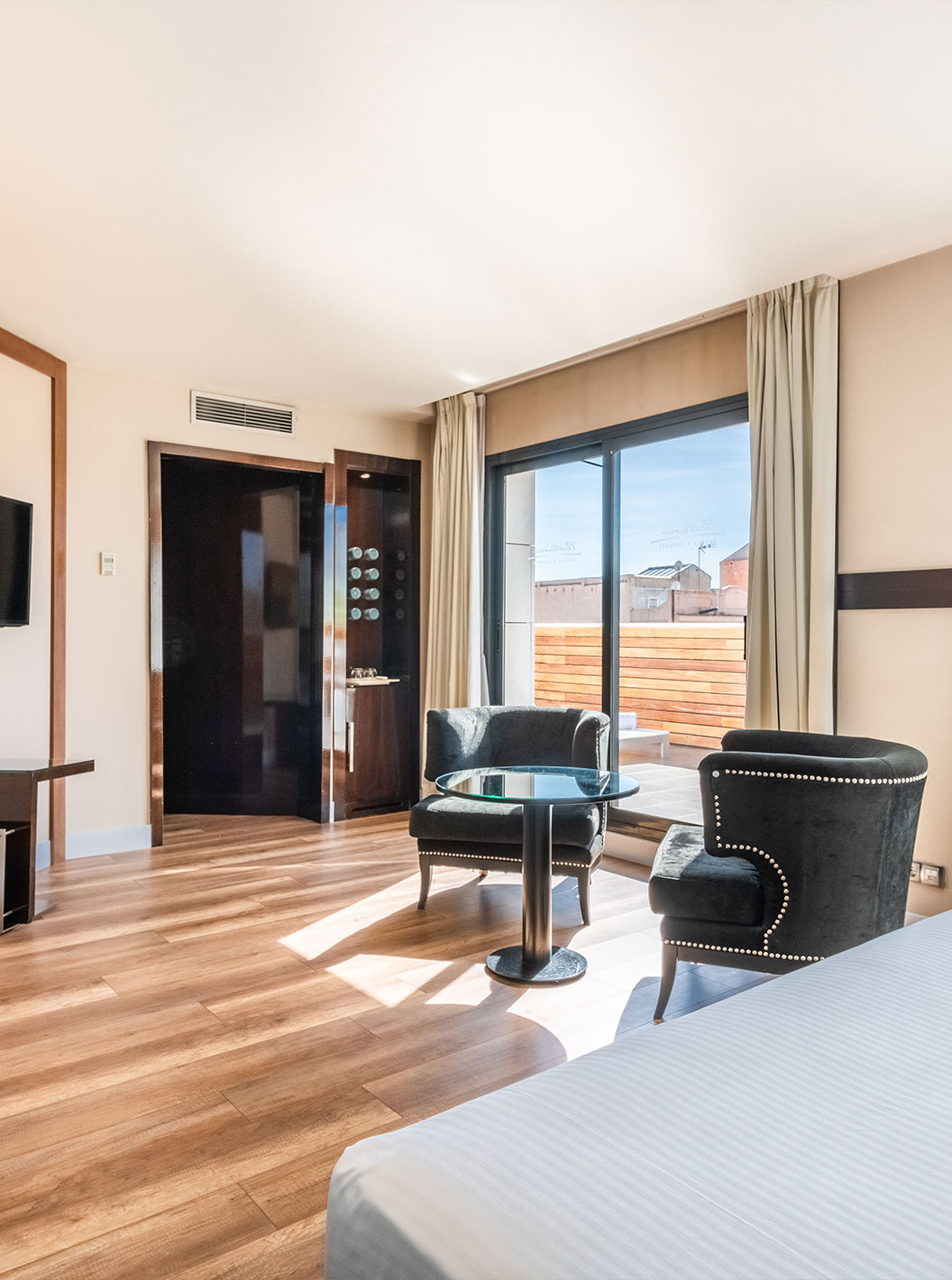 La Junior Suite du Pestana Arena Barcelona a un balcon avec table et chaises, et vue sur la ville de Barcelone