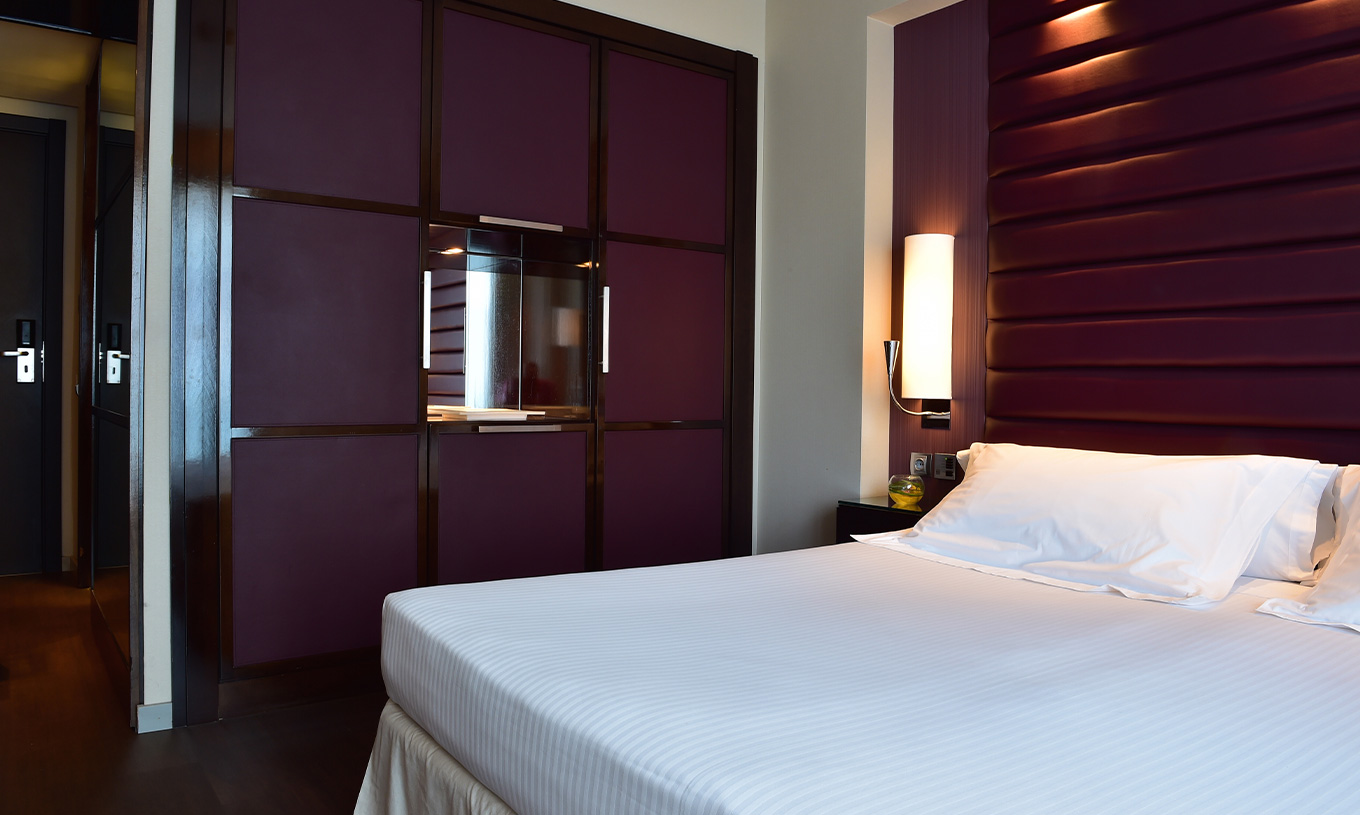 La chambre Premium du Pestana Arena Barcelona a un couloir à l'entrée et un placard pour rangement, avec un miroir