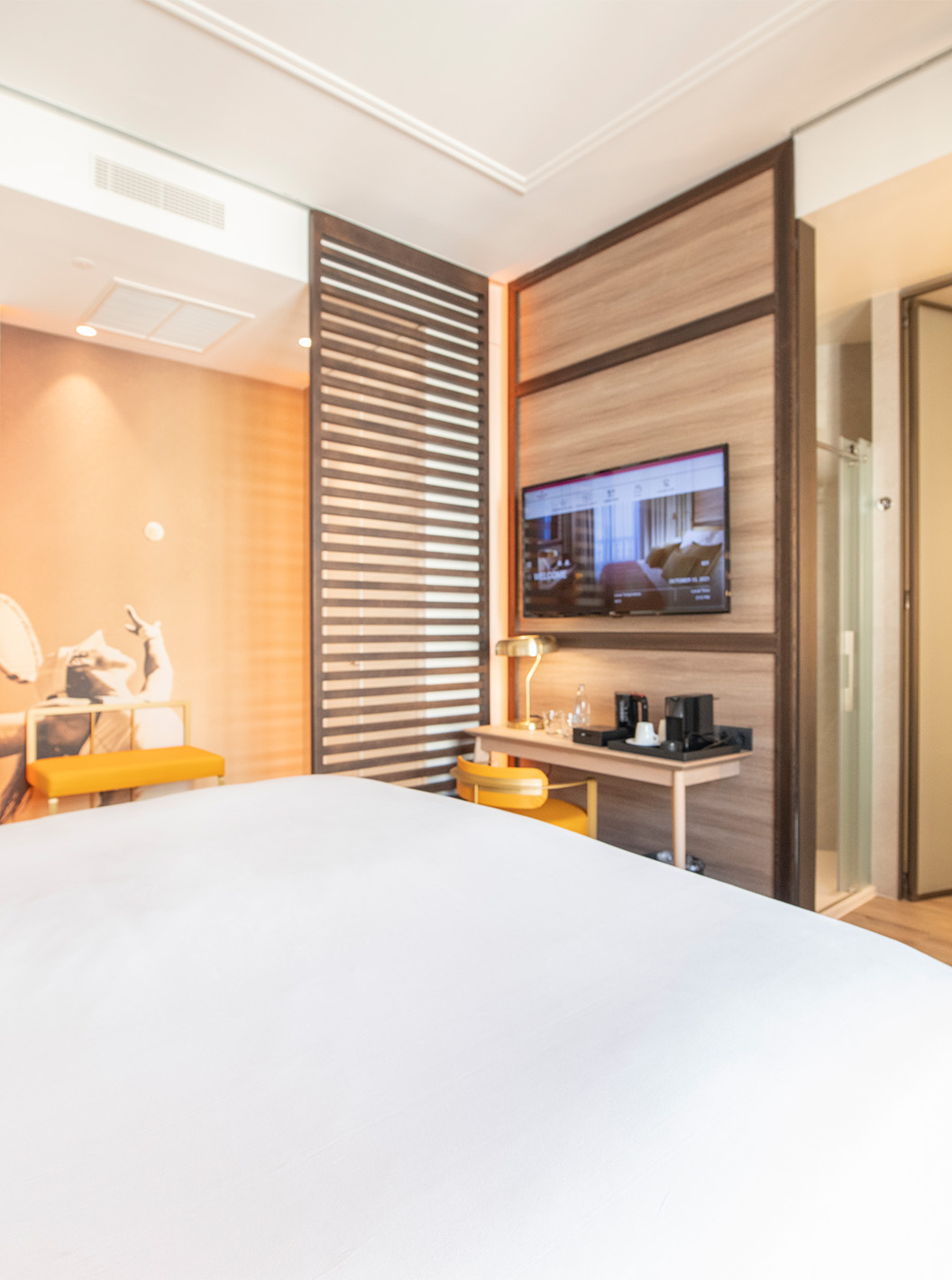 La chambre Legend du Pestana CR7 Gran Vía Madrid a un lit double, une chaise, deux bancs et une cloison en bois