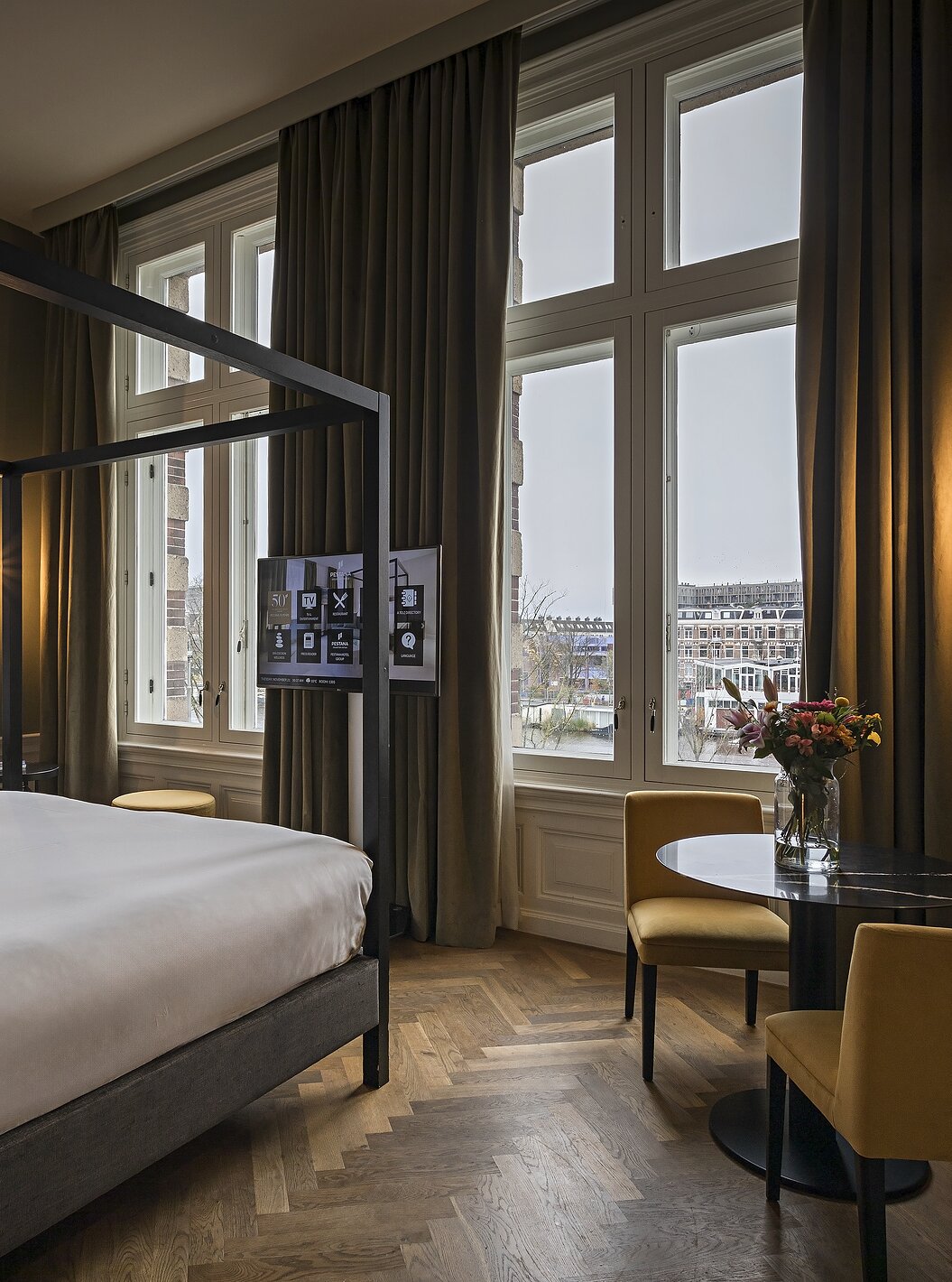 La Presidential Suite - Vue Rivière du Pestana Amsterdam Riverside a un lit double avec baldaquin et télévision