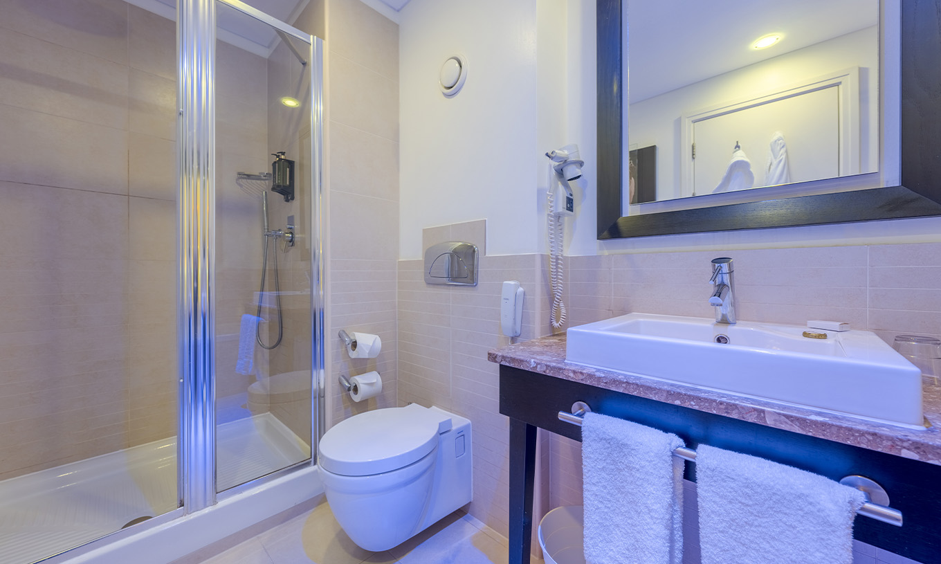 Le Deluxe Premium Twin du Pestana Chelsea Bridge a une salle de bains avec douche, toilettes, lavabo et miroir
