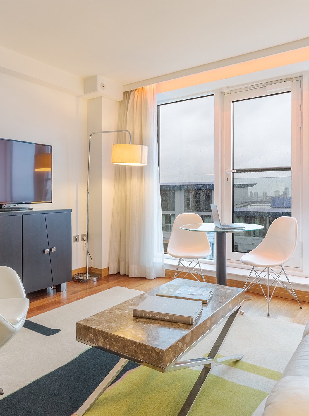 La Suite Exécutive 1 Chambre du Pestana Chelsea Bridge a un salon avec canapé, table basse, télévision et fenêtres