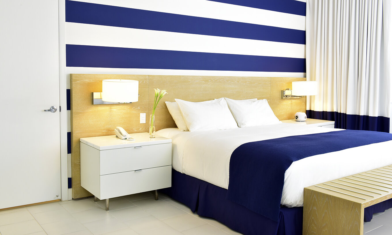 Le Pestana Deluxe Lit Queen - ADA du Pestana Miami South Beach a un lit double, lampe et table de chevet