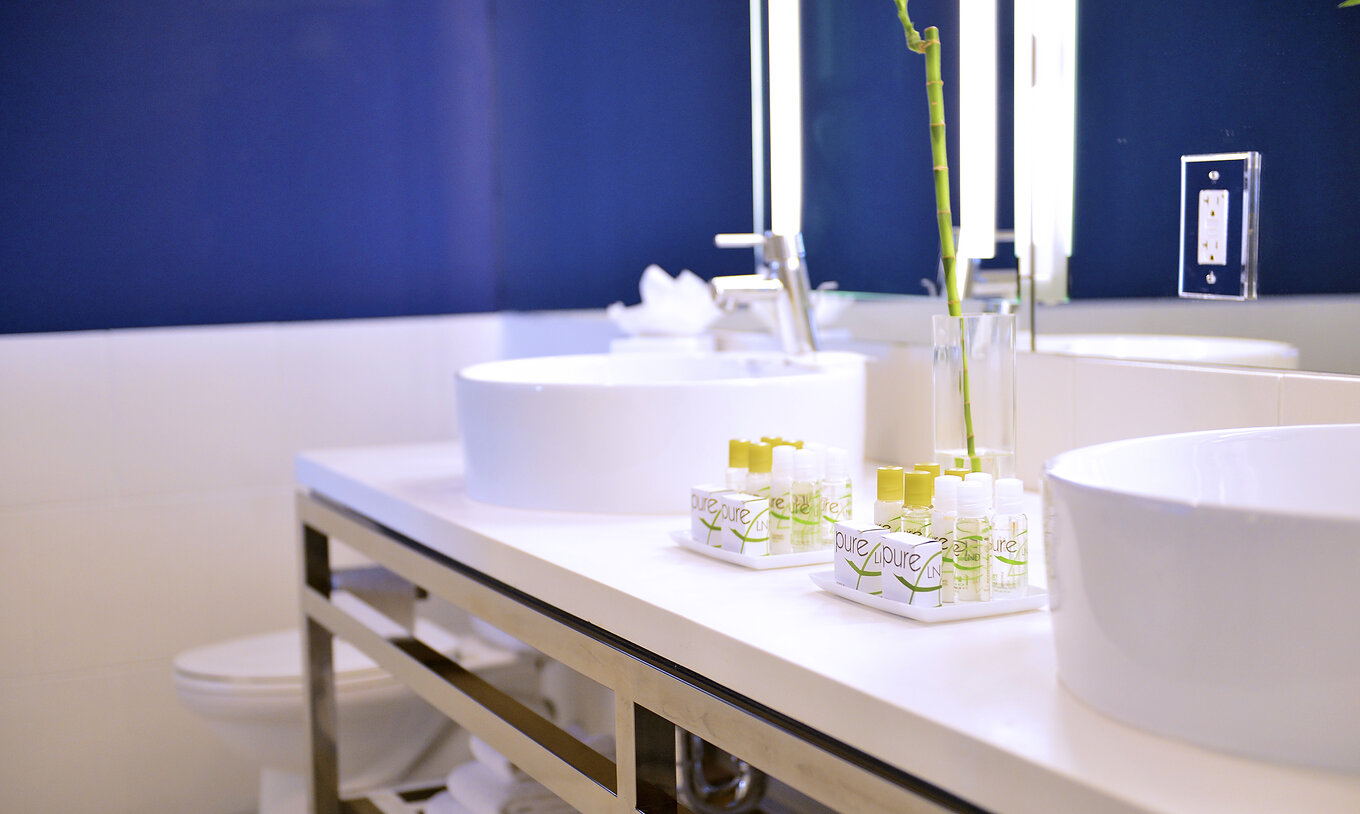 La chambre South Beach King - ADA du Pestana Miami South Beach a lavabo, miroir, douche et toilettes