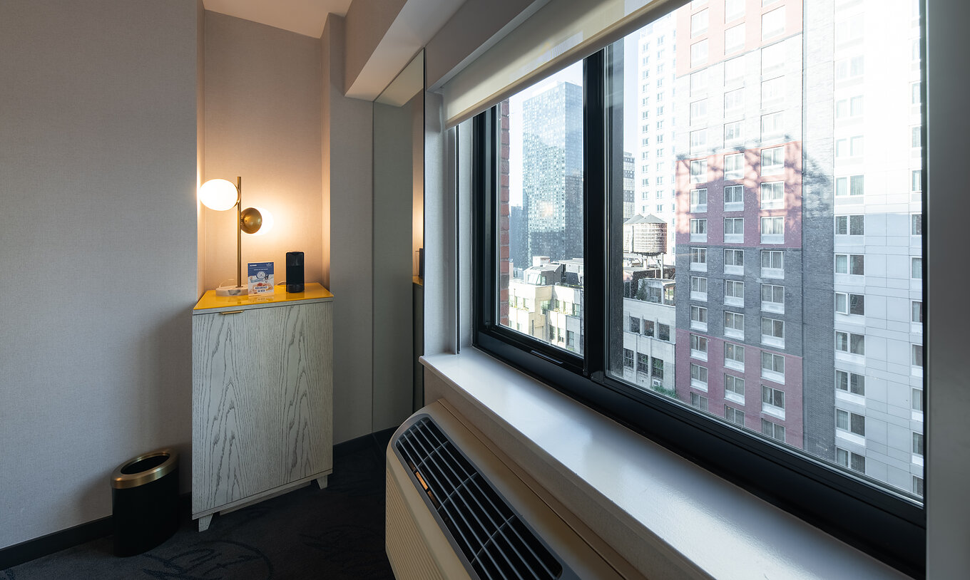 Le Deluxe King Room ADA du Pestana CR7 Times Square a une fenêtre avec vue sur la ville et la climatisation
