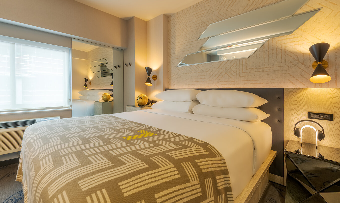 Le Comfort ADA du Pestana CR7 Times Square a un lit double avec une couverture numéro sept et une armoire