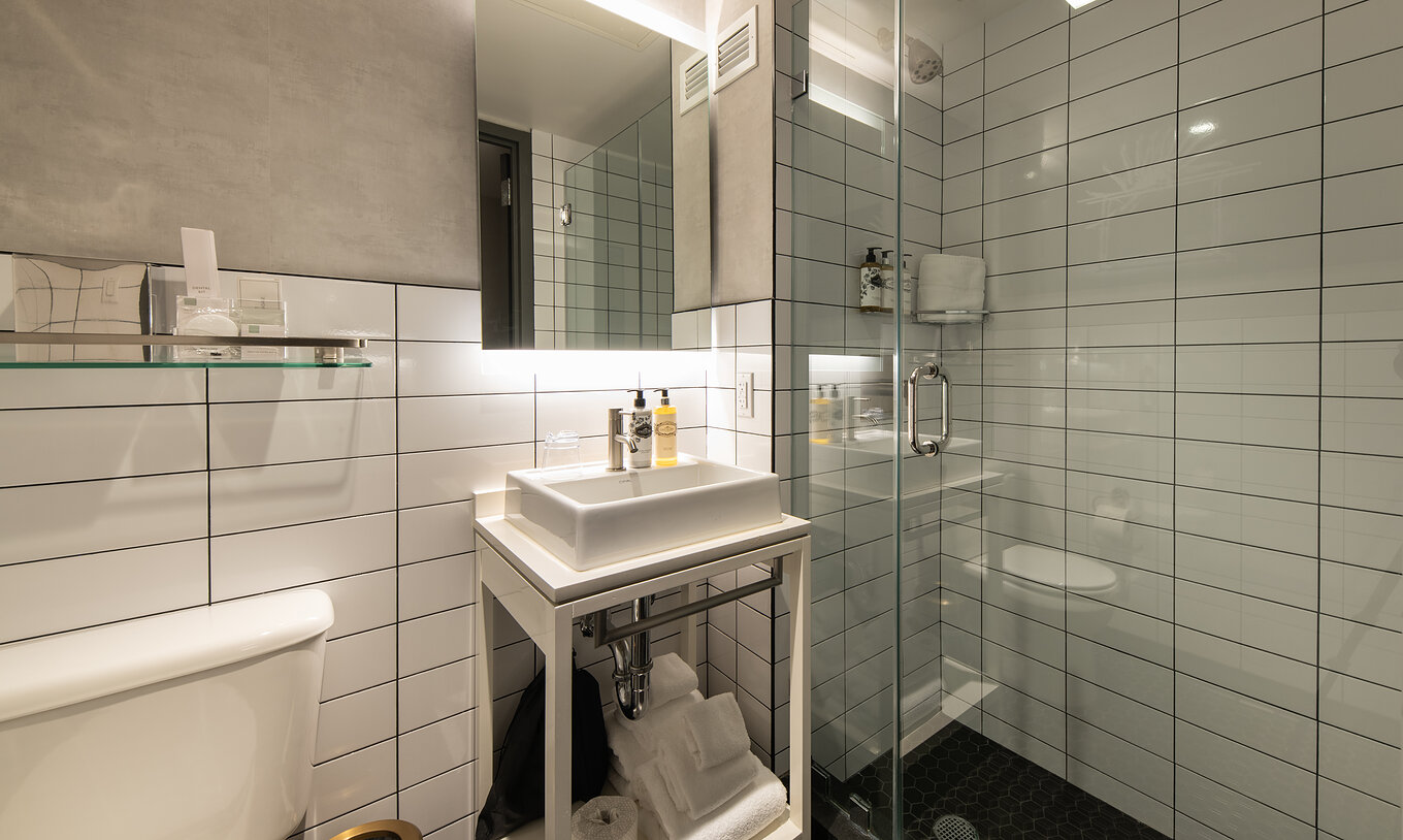Le Comfort Street View du Pestana CR7 Times Square a une salle de bain avec douche, lavabo, miroir et toilettes