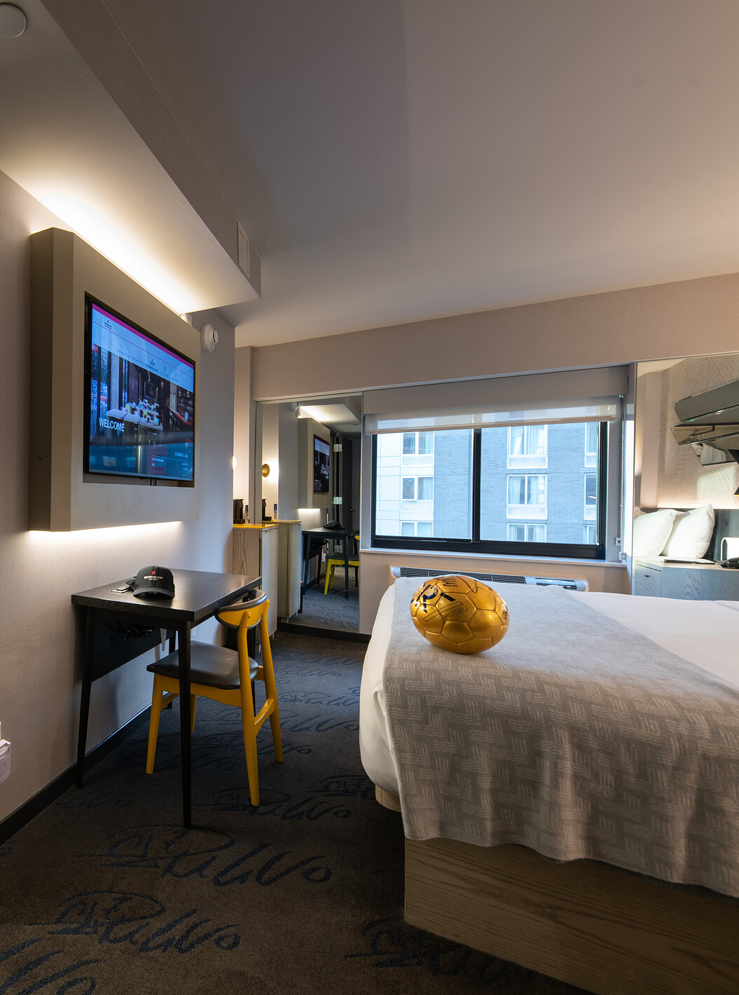 Le Deluxe King Room du Pestana CR7 Times Square a une salle de bain à côté de la chambre avec un lavabo