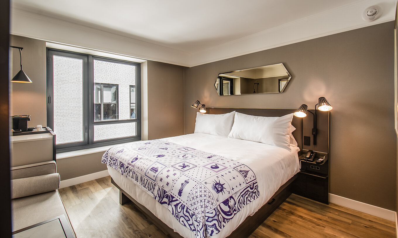 La chambre Classique du Pestana Park Avenue a un lit double, une table de nuit avec lampe et téléphone