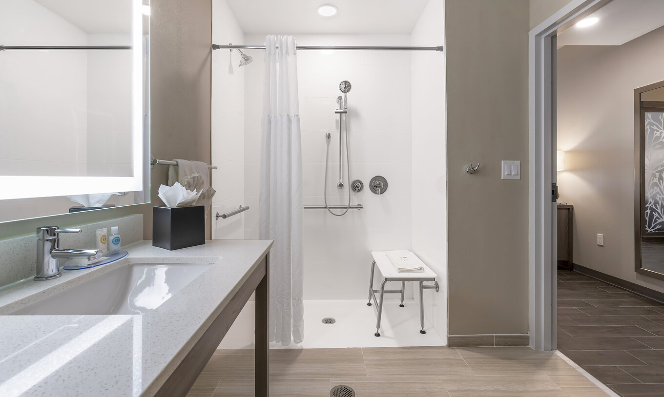 La Suite Double Queen ADA du Pestana Orlando Suites Lake Buena Vista a une salle de bain avec douche adaptée et lavabo