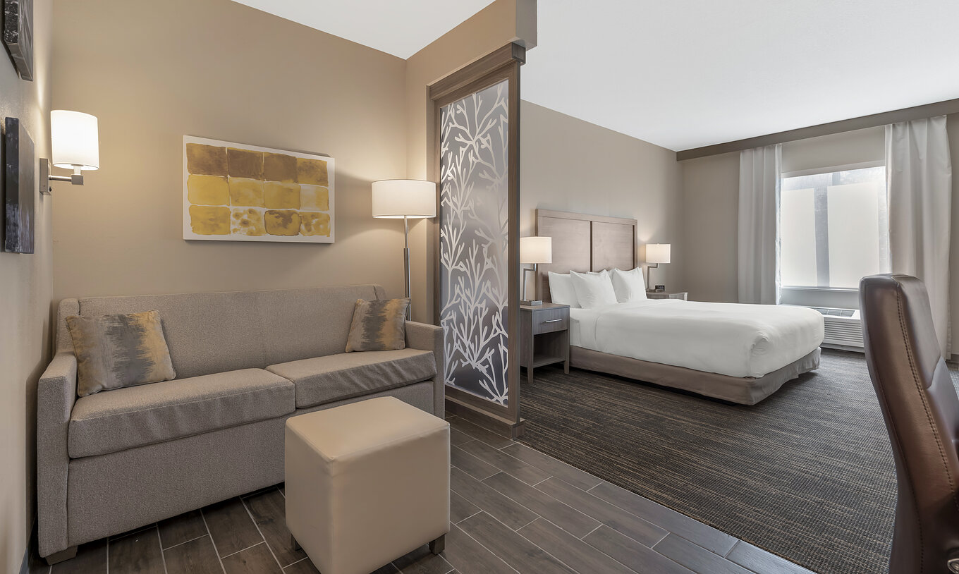 La Suite ADA King du Pestana Orlando Suites Lake Buena Vista a un lit double, table de chevet, canapé et lampe