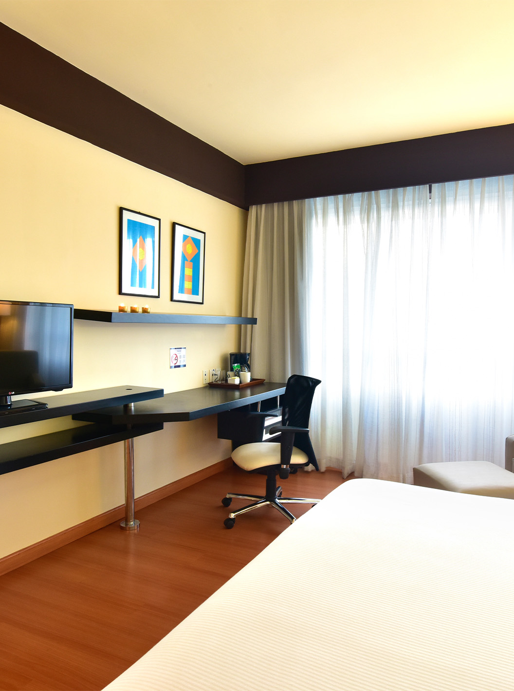 Le Twin Superior du Pestana Caracas a une télévision au fond du lit, une poltrona, un bureau et une fenêtre