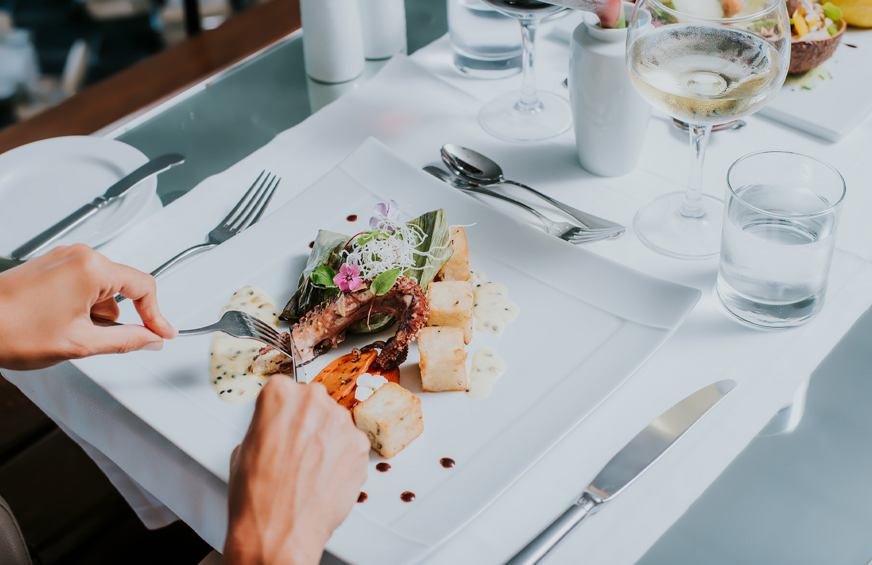 Assiette blanche avec du poulpe et du maïs frit, pendant un repas dans un hôtel de la marque Pestana Hotels and Resorts