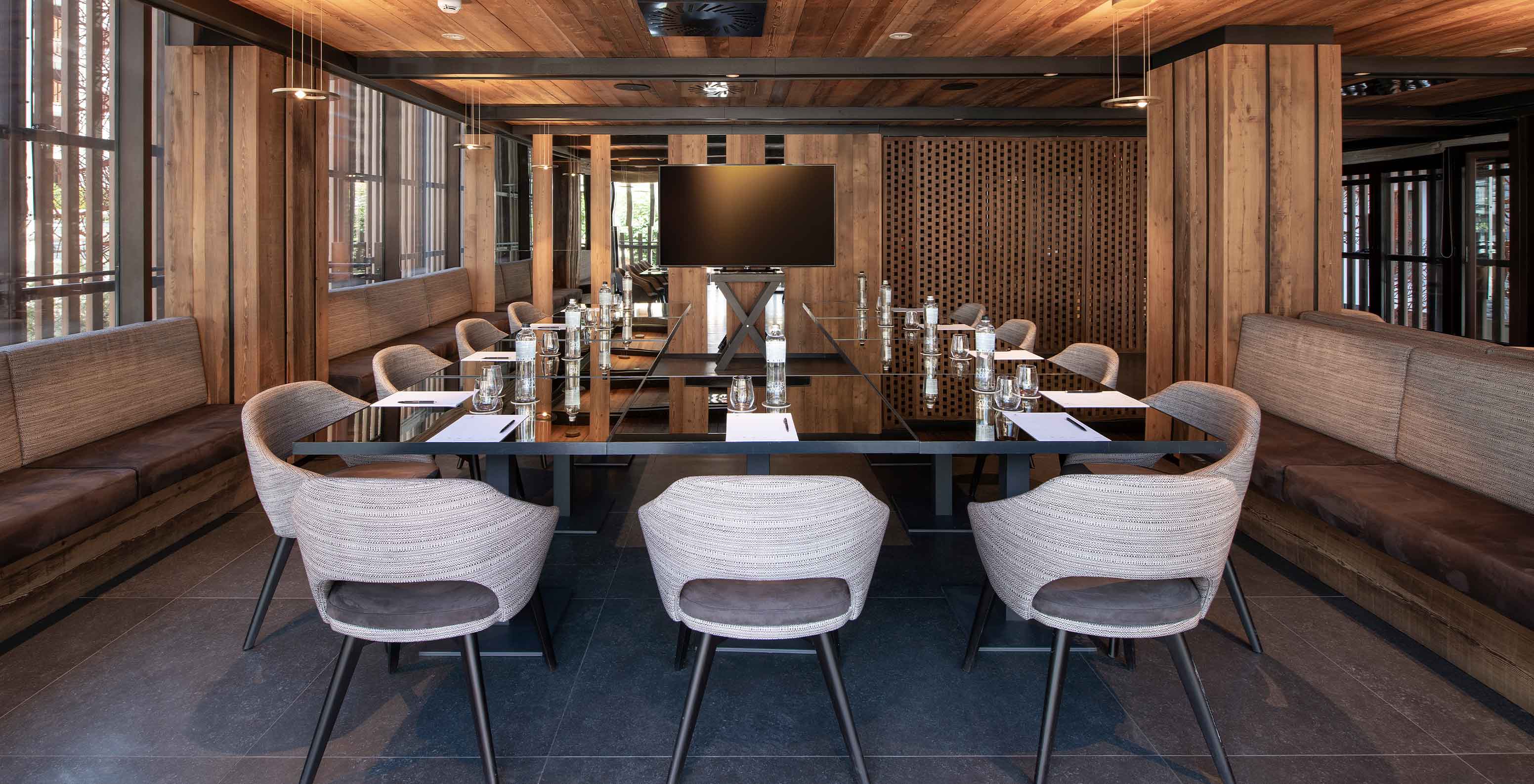 Sala de reuniões do Le Massif Courmayeur, Hotel nos Alpes Italianos, com mesa grande e cadeiras modernas