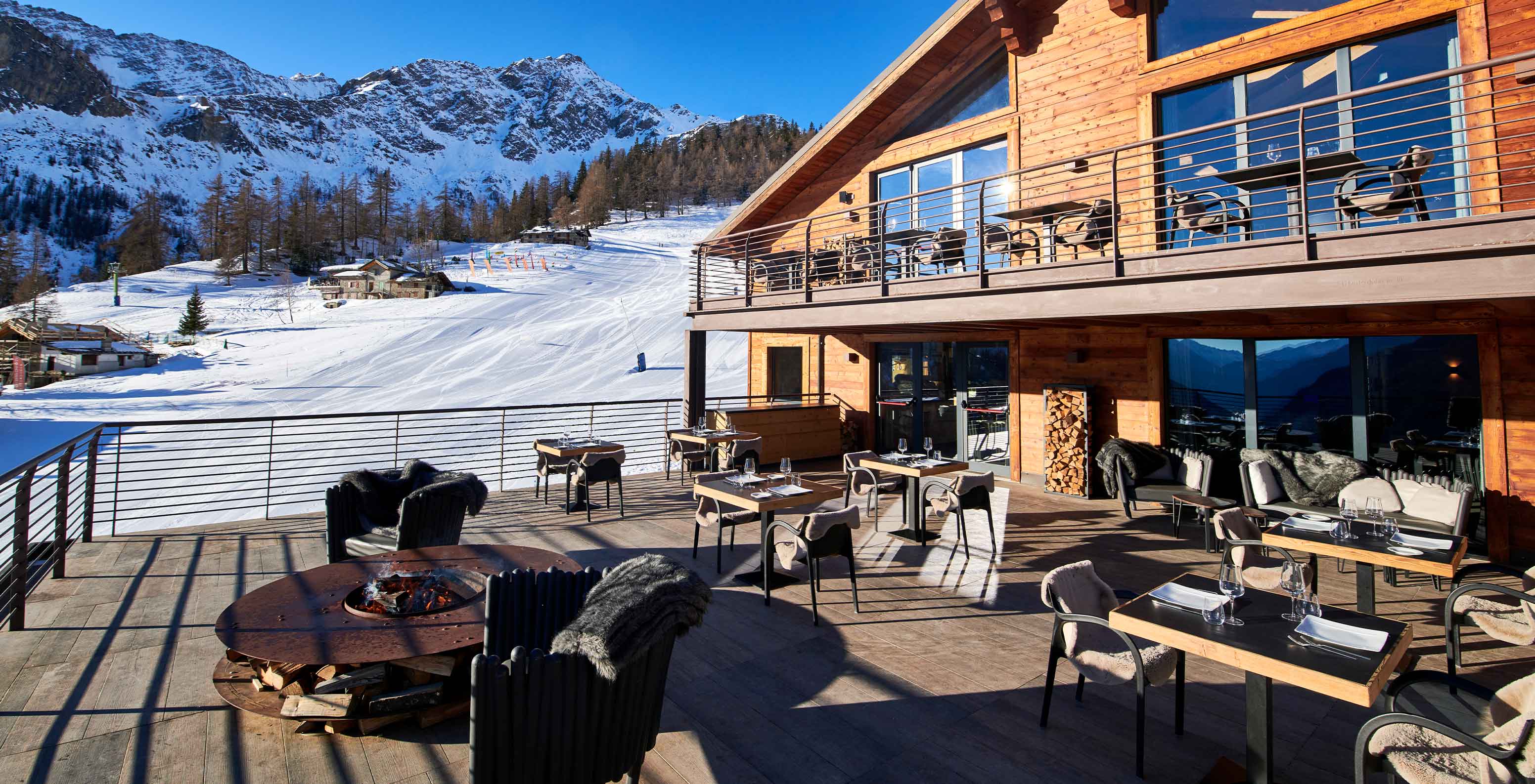 Le Massif Courmayeur, Hotel nos Alpes Italianos em Courmayeur para fazer ski, terraço de restaurante com mesas e vista para montanhas nevadas