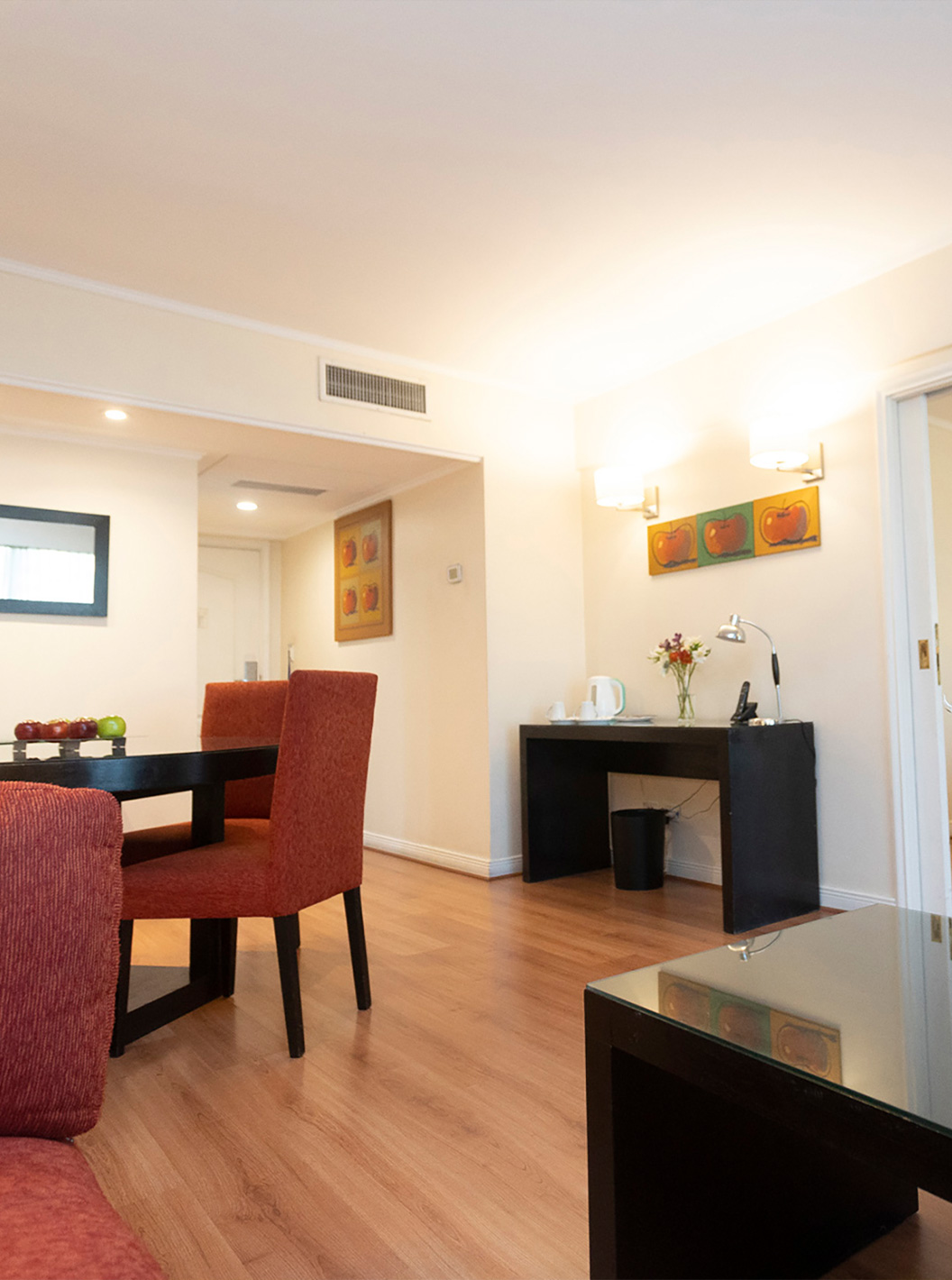 De Queen Suite van Pestana Buenos Aires heeft tafel met stoelen, spiegel, telefoon en salontafel