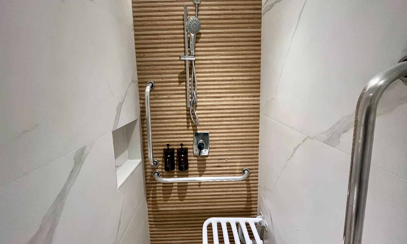 De Semi-Aangepaste Kamer van Pestana Rio Atlântica heeft douche met steunen, dispensers en opklapbare zitting