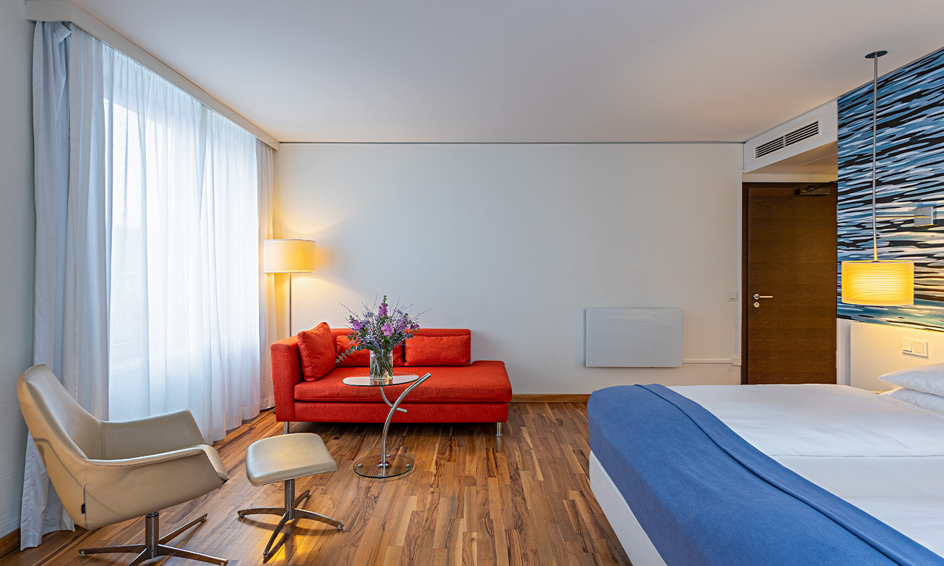 De Grand Deluxe Kamer van Pestana Berlin Tiergarten heeft tweepersoonsbed, bank, salontafel en fauteuil