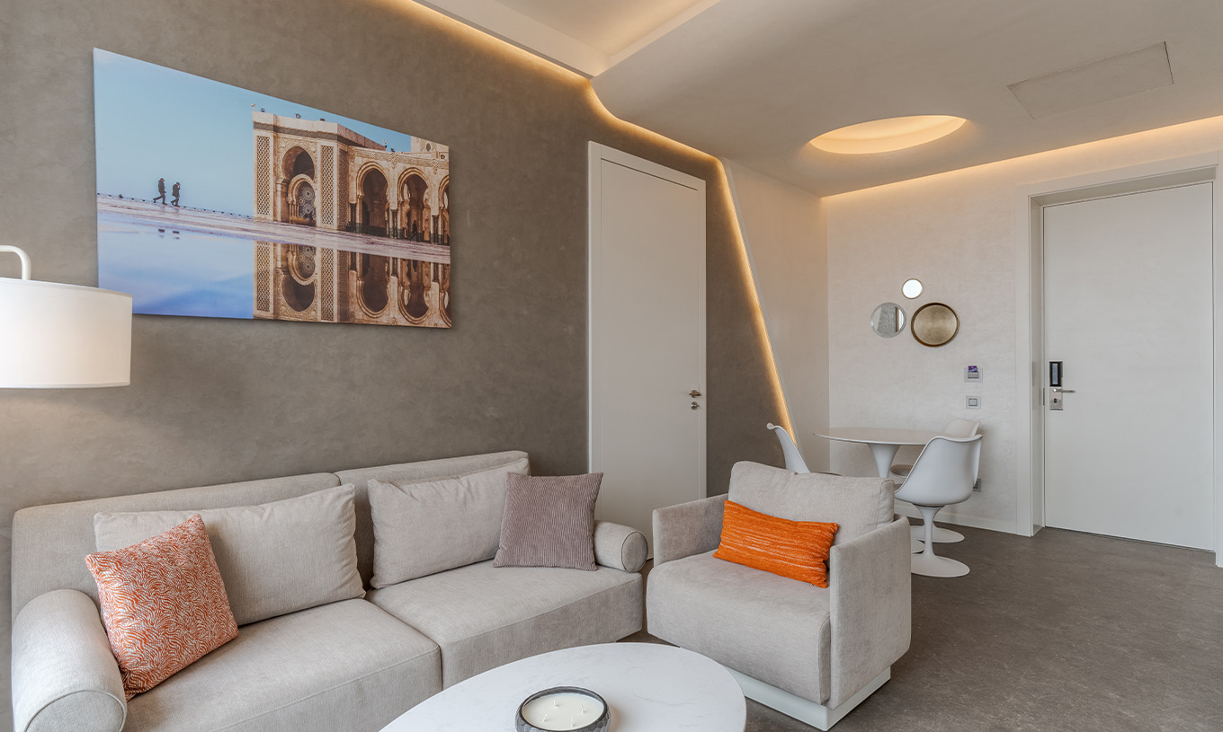 De CR7 Suite van Pestana CR7 Marrakech heeft een woonkamer met twee banken, een schilderij en een eettafel