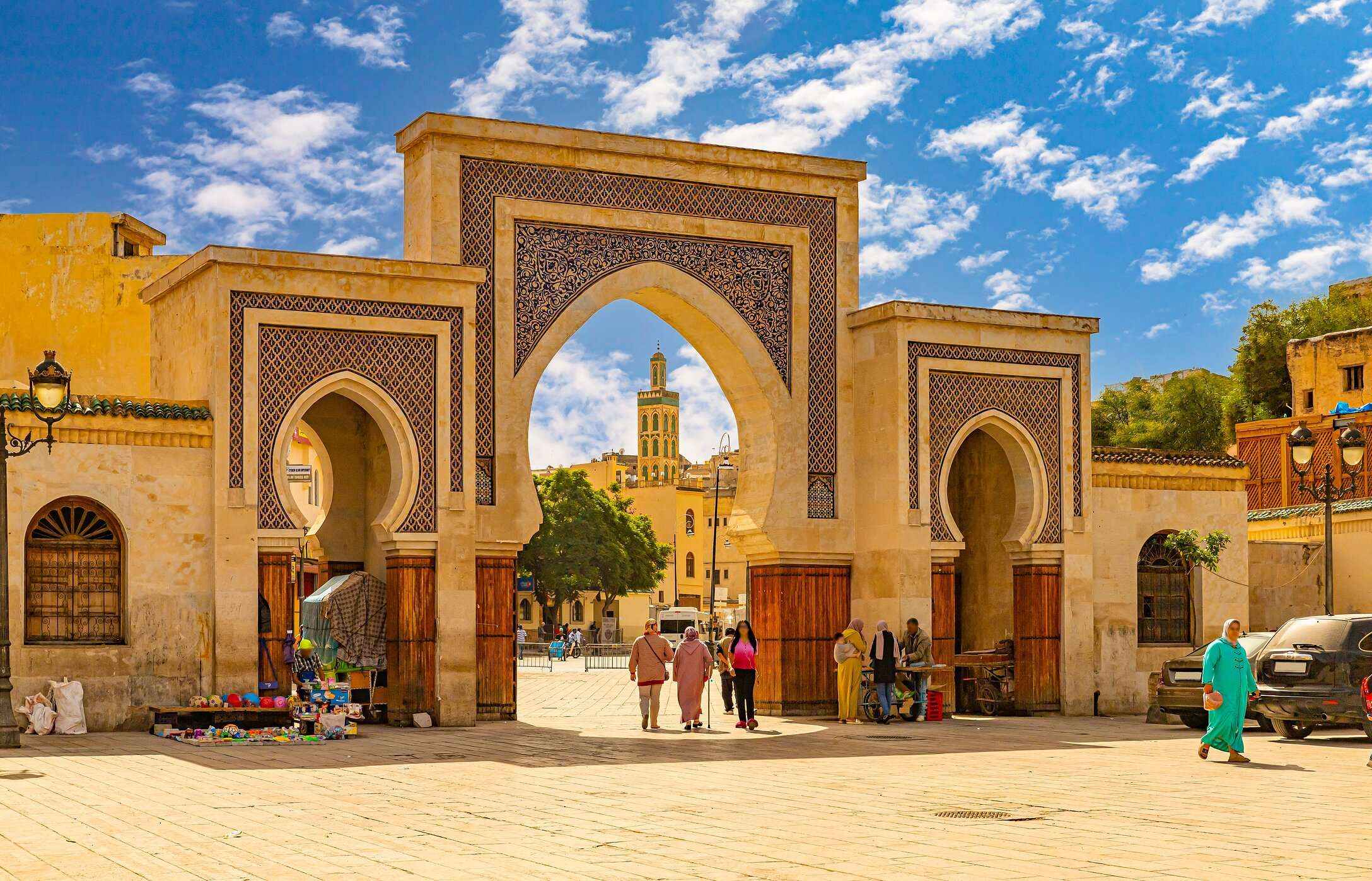 Typische Marokkaanse bogen in Fez, met zandkleurige tegels en mensen in traditionele kleding.