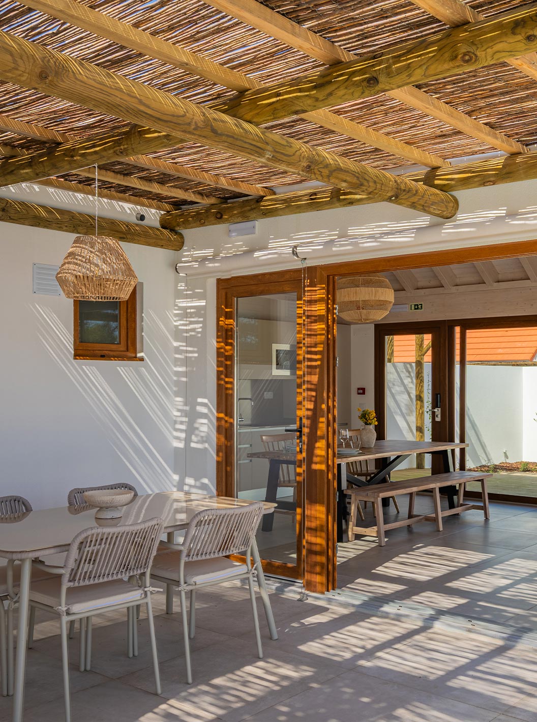 De Premium Villa bij Pestana Comporta Village Residences heeft een overdekte patio met een tafel die leidt naar het interieur