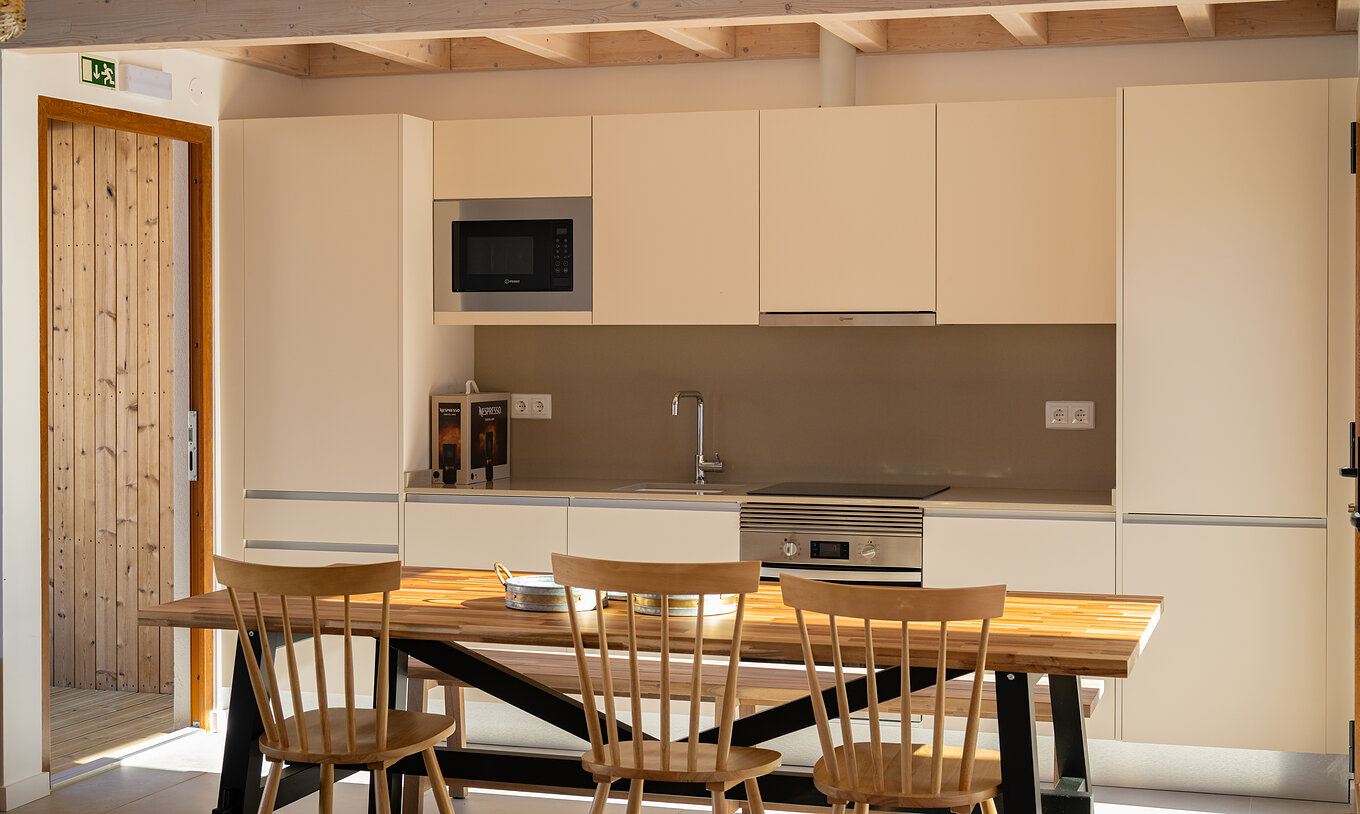 De Superieure Groene Villa bij Pestana Comporta Village Residences heeft een keuken en een tafel met houten stoelen