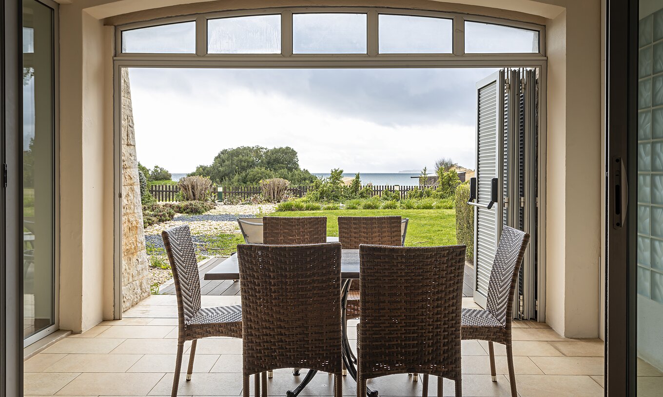 Het Cliff Family in Pestana Alvor Praia heeft een veranda met een tafel en stoelen en een tuin met uitzicht op het strand