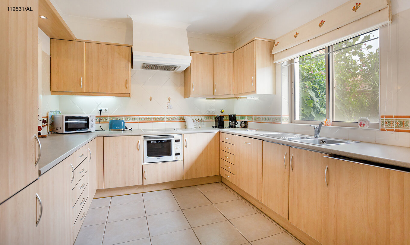 Het appartement Pestana Carvoeiro Golf T1 Standard heeft een keuken met houten kasten en apparatuur