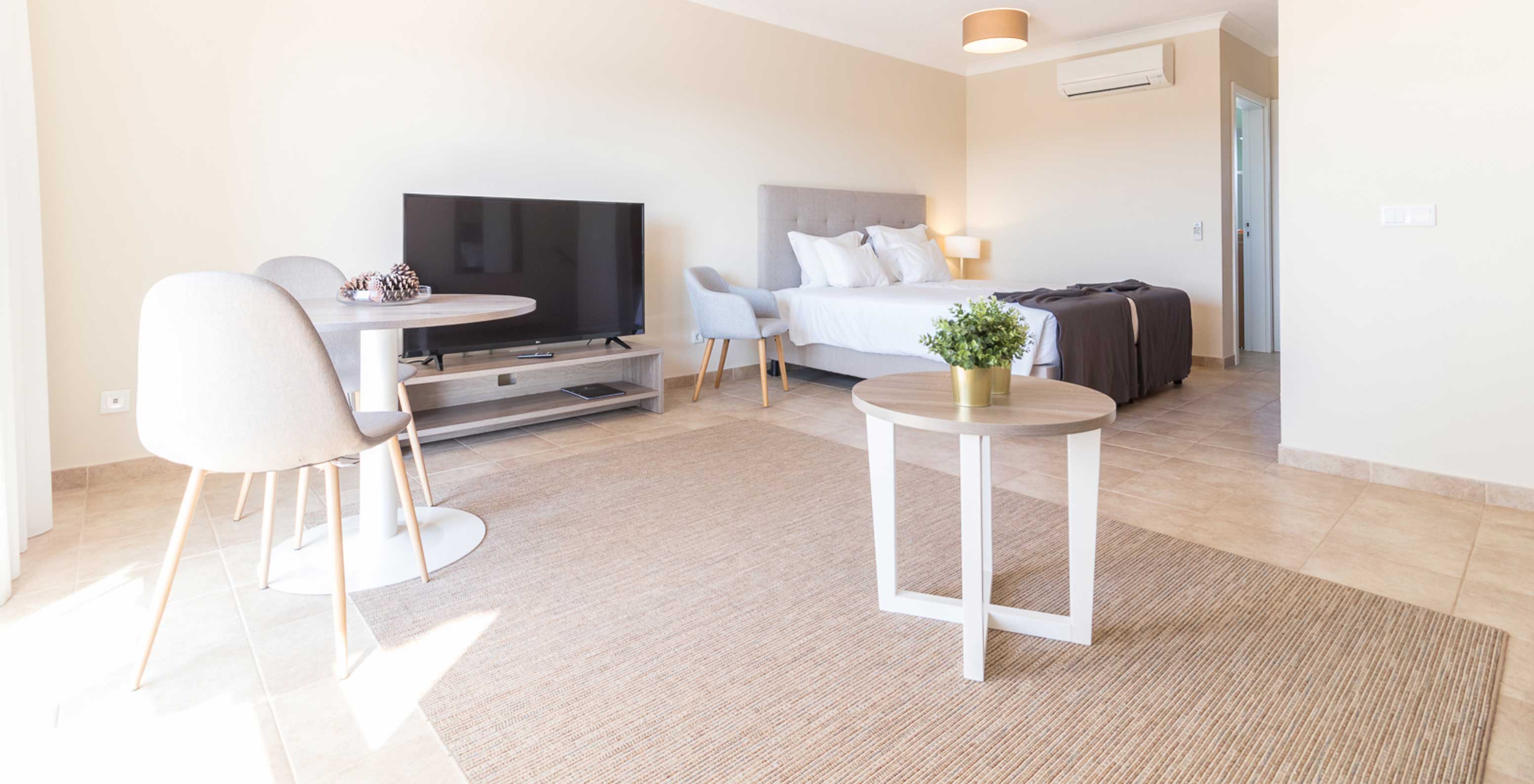De studio van Pestana Gramacho Residences is modern met bed, tv, tafel en minimalistische inrichting