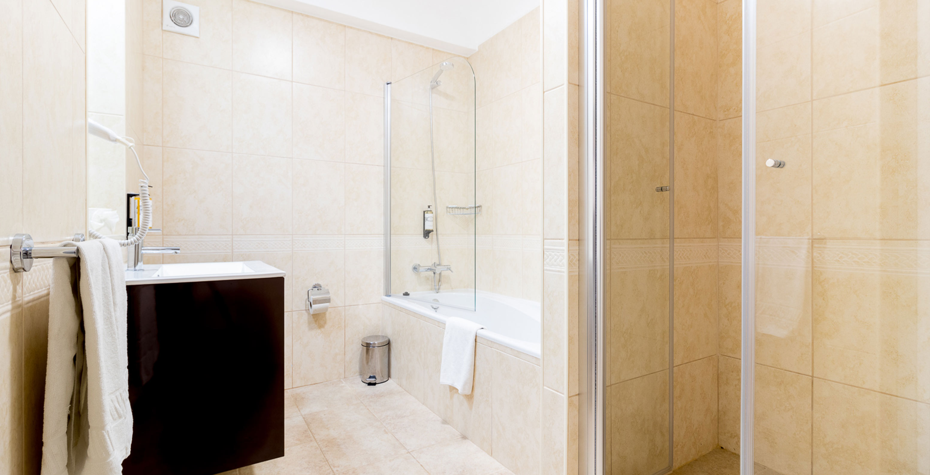 Het éénslaapkamerappartement bij Pestana Gramacho heeft een lichte badkamer met bad, douche en moderne wastafel