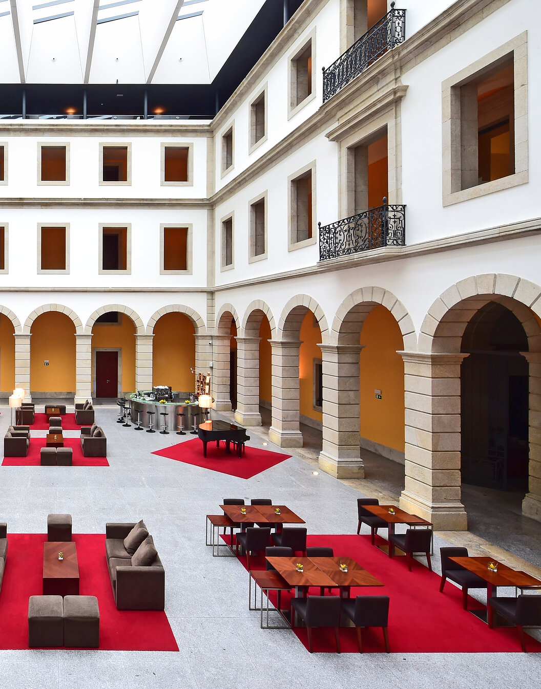 Binnenplaats van Pousada Viseu, Historisch Hotel in Viseu, met bogen rondom en banken en een bar