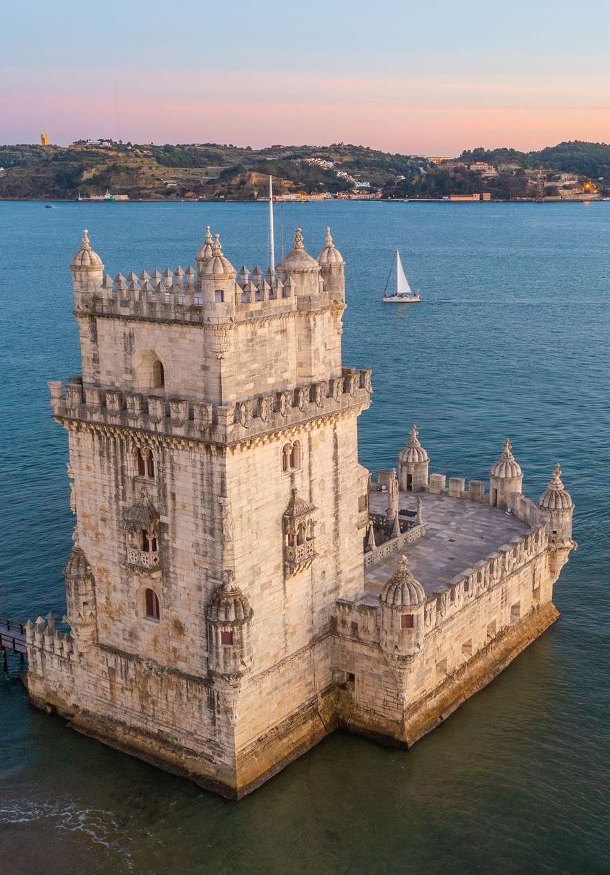 Toren van Belém aan de Taag nabij Pousada Queluz, Hotel Histórico em Queluz bij zonsondergang met zeilboot