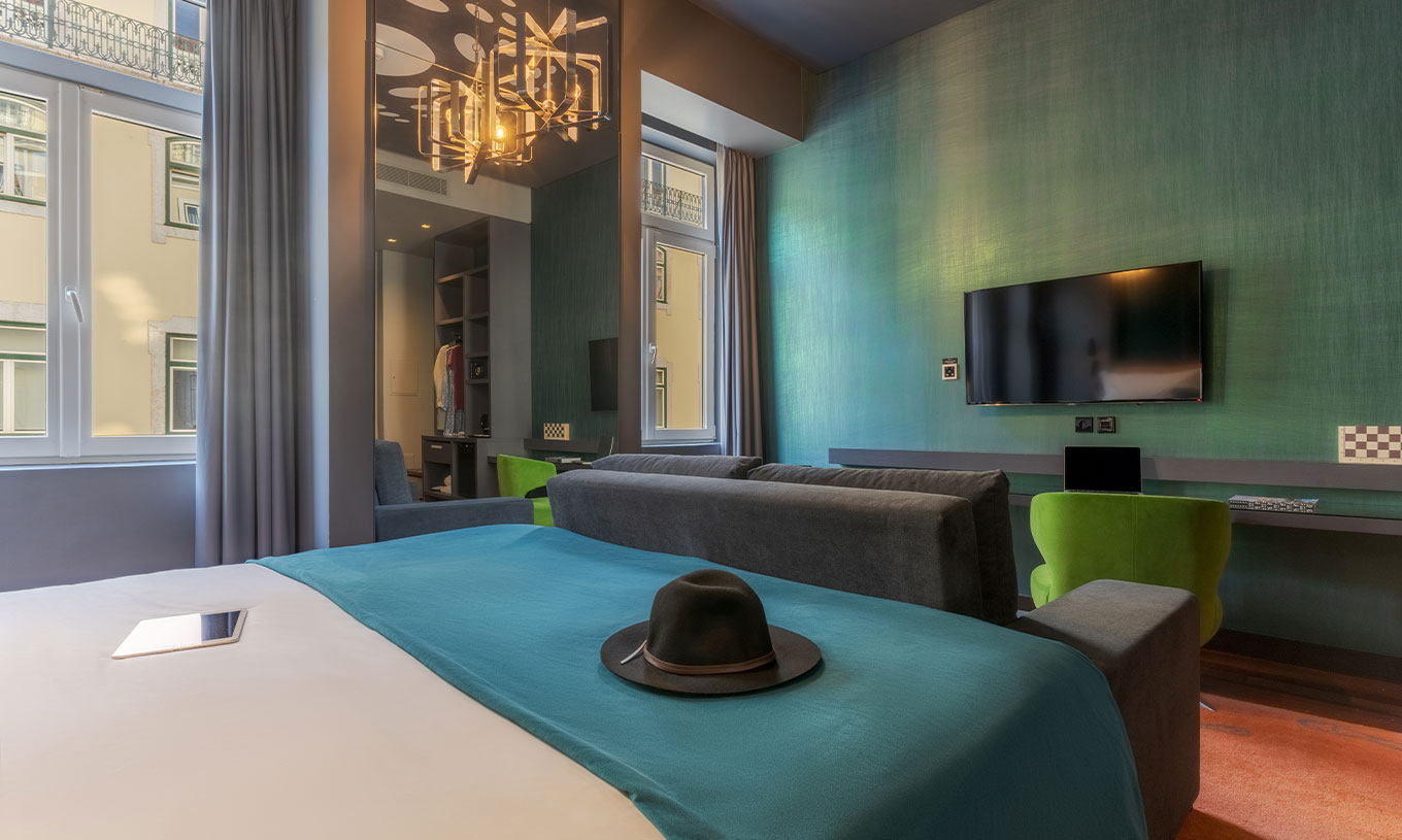 De CR7 Familie Hat-Trick van Pestana CR7 Lisboa heeft een spiegel, een bank met televisie en een bed