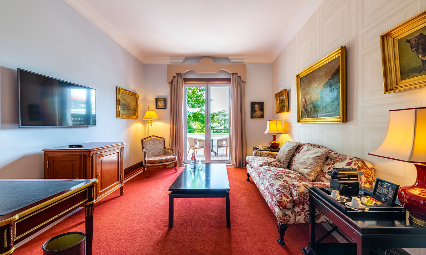 De Suite Collection van Pestana Palace Lisboa heeft een kamer met bank, televisie, raam met balkon en schilderijen