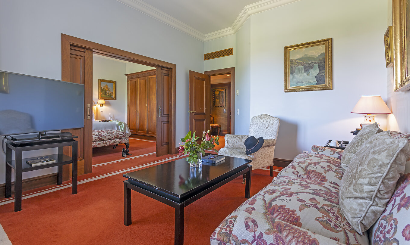 De Suite van Pestana Palace Lisboa heeft een woonkamer met een bank en een fauteuil, een salontafel en een televisie