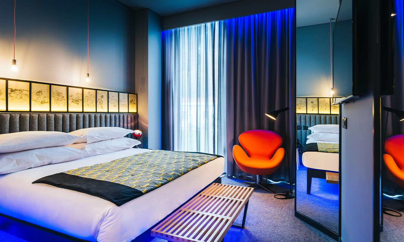 De CR7 Room van Pestana CR7 Funchal heeft een ruime ruimte met een tweepersoonsbed, steunbank en comfortabele stoel