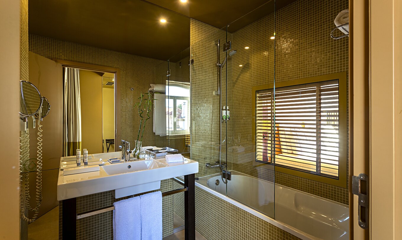 De Deluxe Grand View heeft een badkamer met bad en een raam naar de slaapkamer