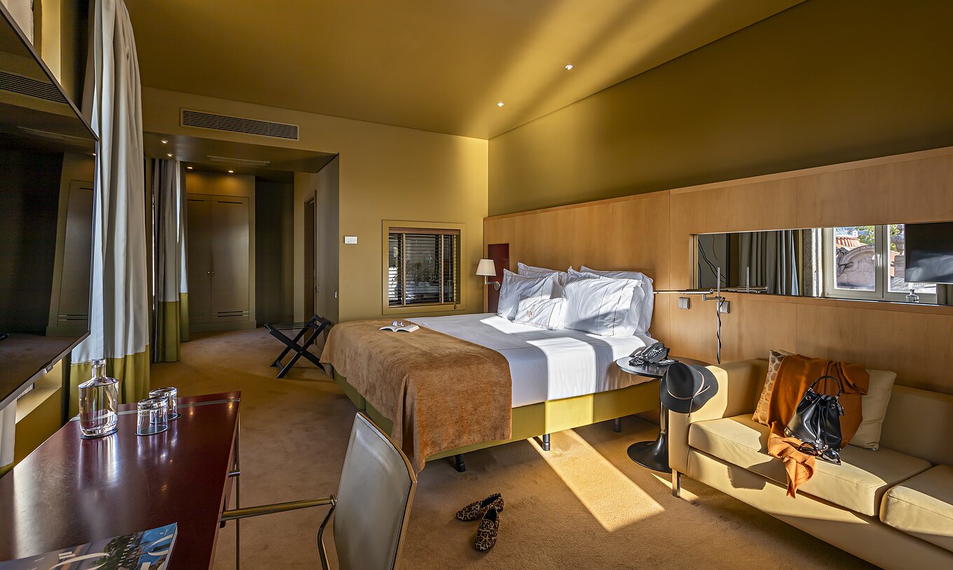 De Deluxe Grand View heeft een tweepersoonsbed met een camel-kleurige deken, een bank en een bureau