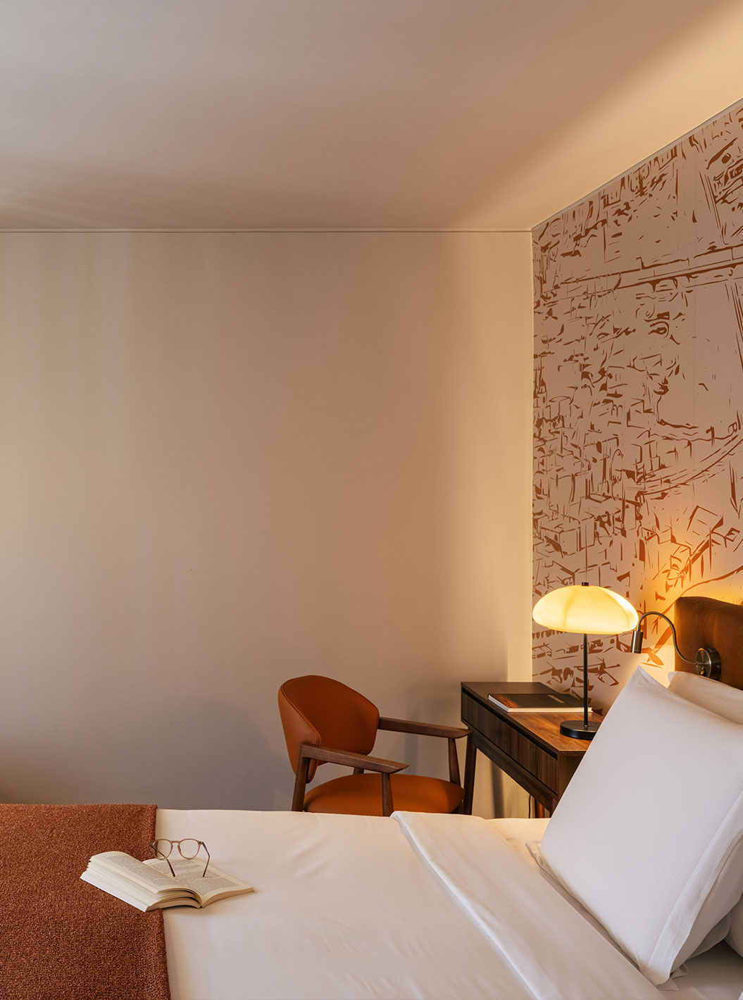 Klassieke kamer in Pestana Vintage Porto met bed, fauteuil, bureau en warme verlichting naast het raam