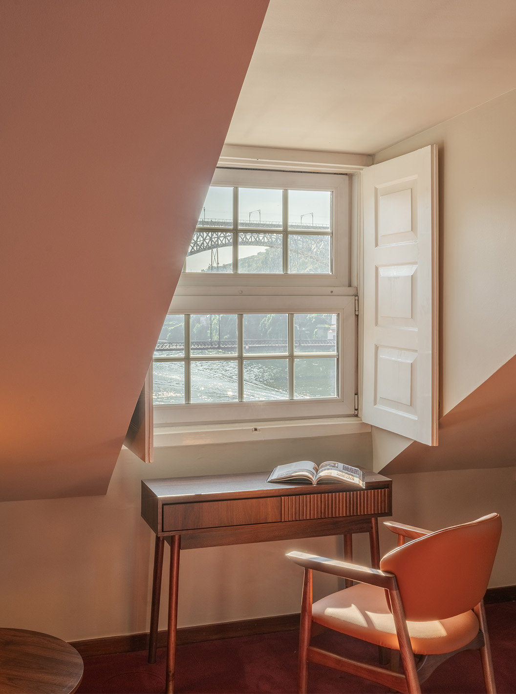 Heritage Familiesuite van Pestana Vintage Porto met houten bureau, fauteuil en uitzicht op de brug door raam