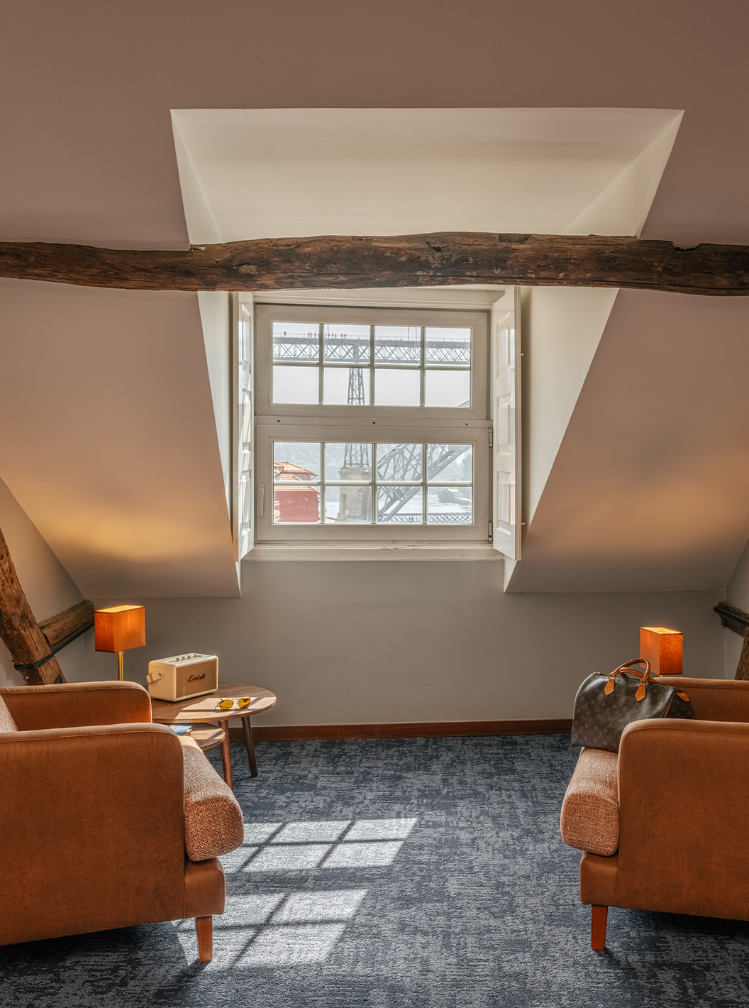 Heritage Familiesuite in Pestana Vintage Porto met twee fauteuils onder houten balken en uitzicht op brug