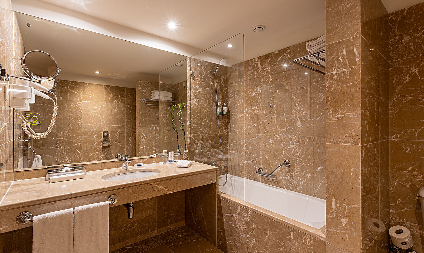 De Suite Grand View van het Pestana Vintage Porto heeft een badkamer met bruine marmeren muren en een bad