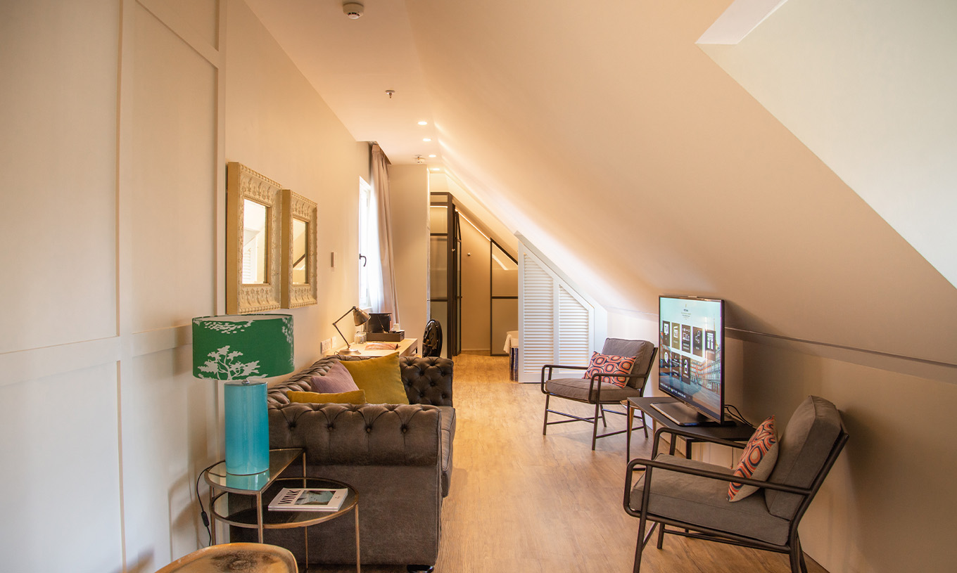 De Suite Plaza Mayor van Pestana Plaza Mayor Madrid heeft een woonkamer met bank stoelen tv en schilderijen aan de muur