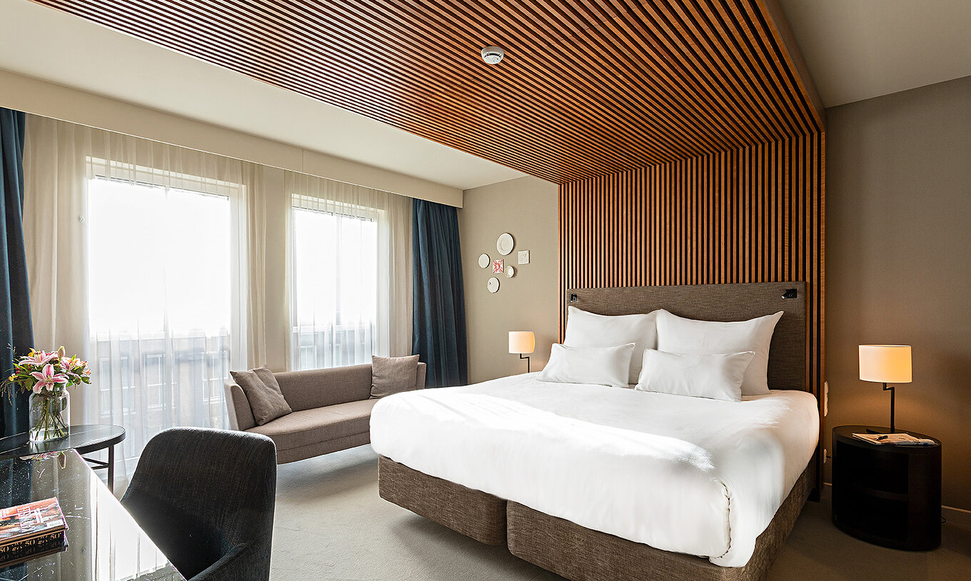 De Executive kamer van Pestana Amsterdam Riverside heeft een tweepersoonsbed, een bank en nachtkastje met lamp