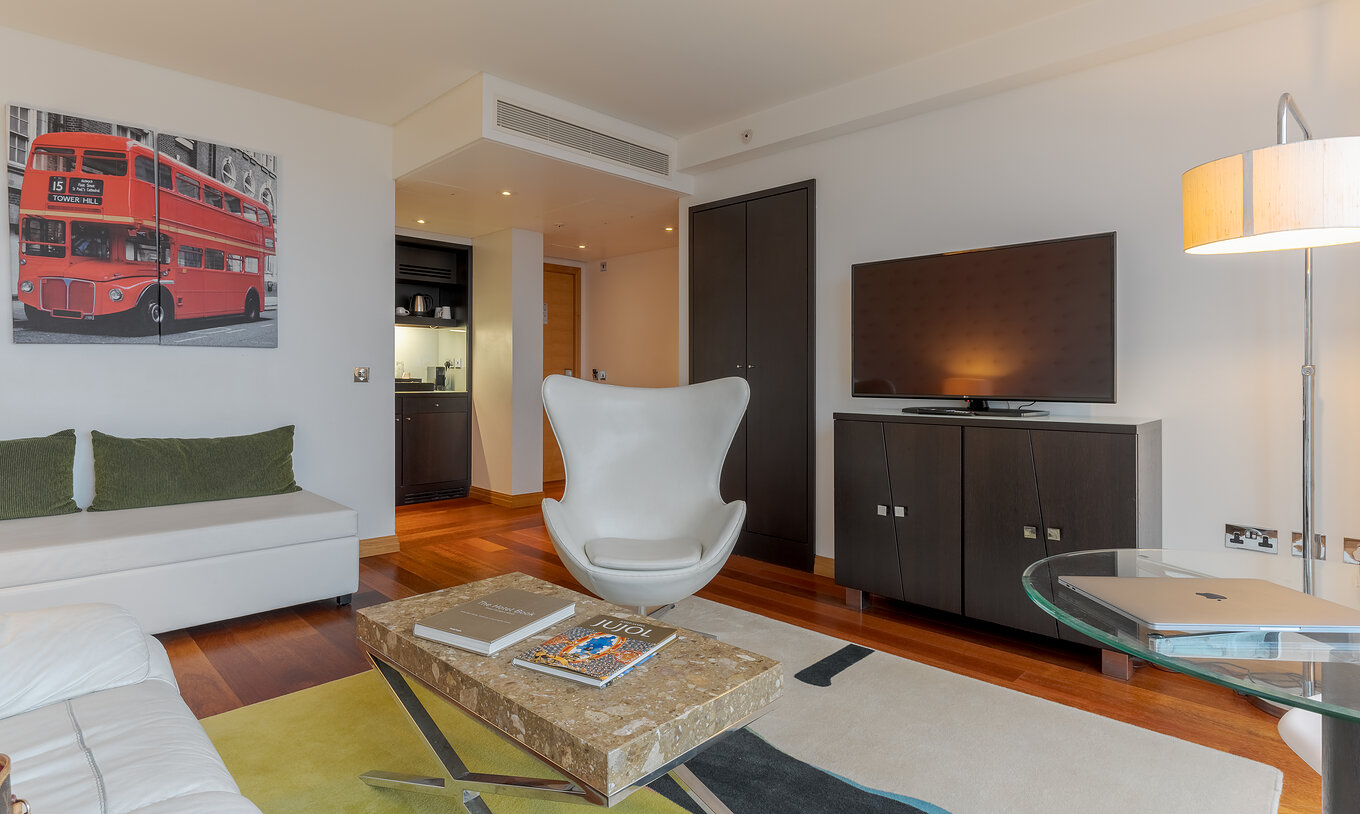 De Executive One Bedroom Suite van Pestana Chelsea Bridge heeft woonkamer met bank, salontafel, fauteuil en tv