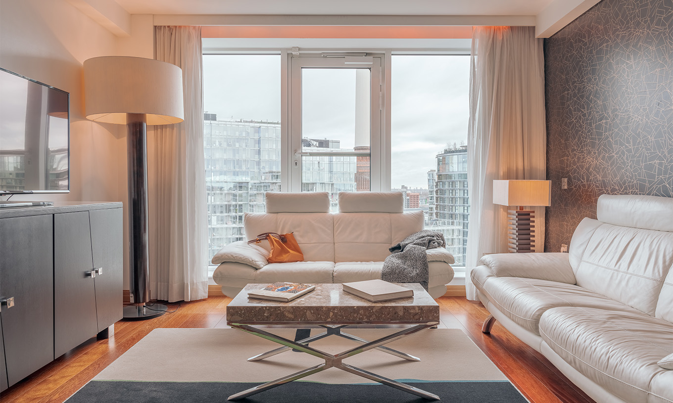 De Signature Suite met 2 Slaapkamers van Pestana Chelsea Bridge heeft een woonkamer met bank, salontafel, televisie en ramen