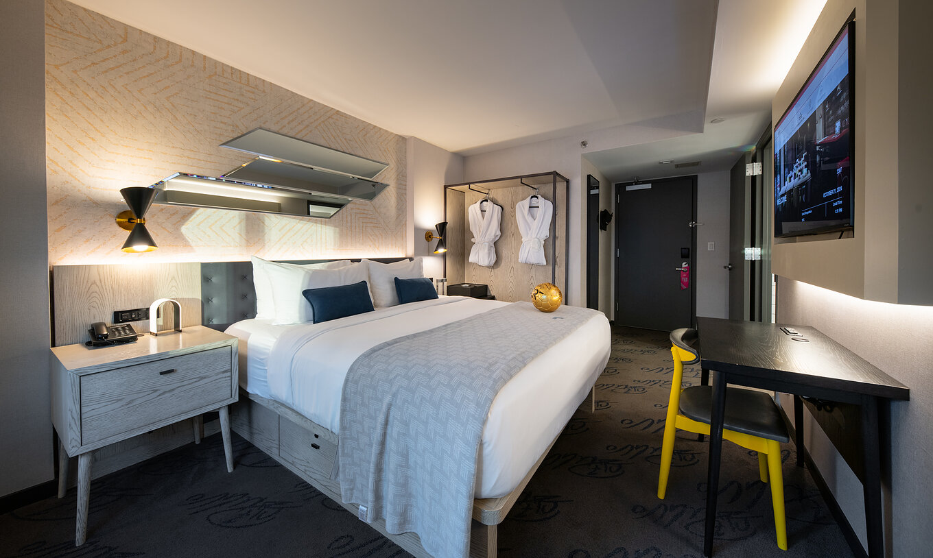 De Deluxe King Room ADA van Pestana CR7 Times Square heeft een tweepersoonsbed, een bureau en een televisie