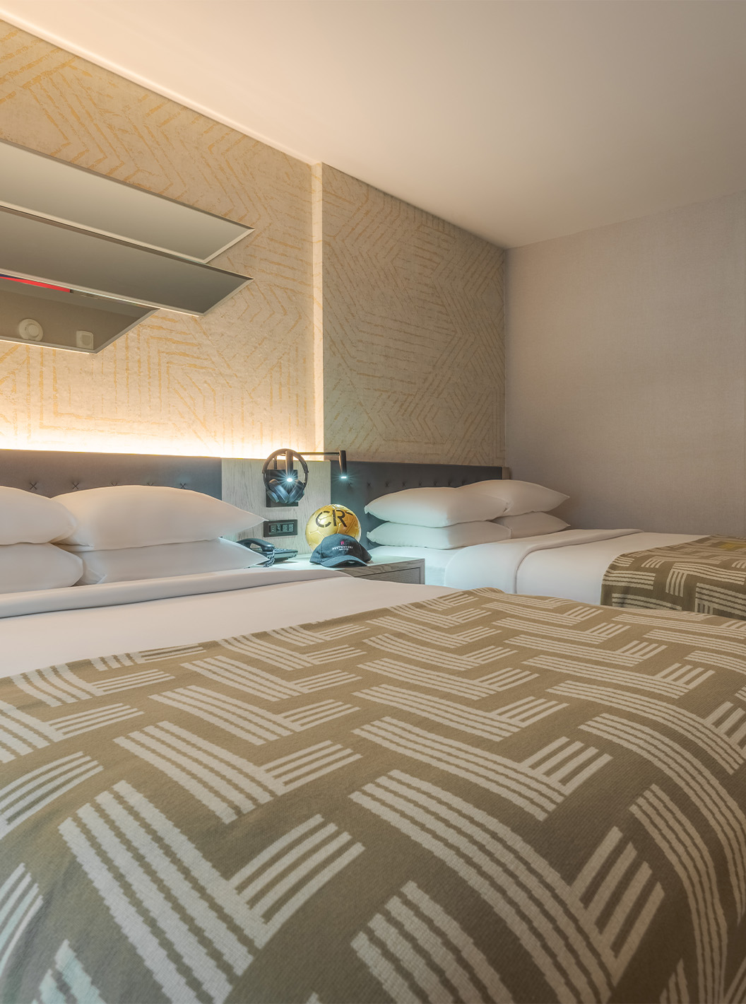 De Comfort Double ADA van Pestana CR7 Times Square heeft twee bedden met een dekbed met het nummer zeven en een kast