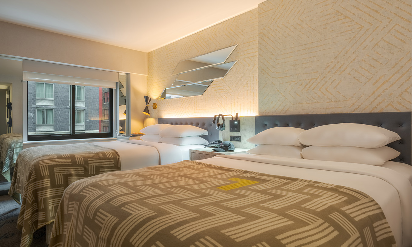 De Comfort Double van Pestana CR7 Times Square heeft twee bedden met een dekbed met het nummer zeven en een raam