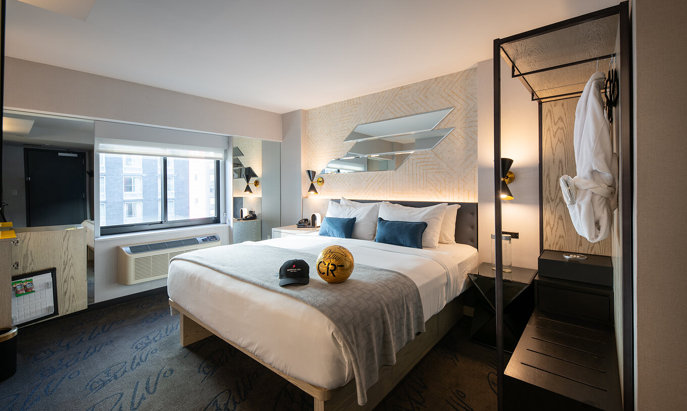 De Deluxe King Room van Pestana CR7 Times Square heeft een tweepersoonsbed, een raam en een kledingkast